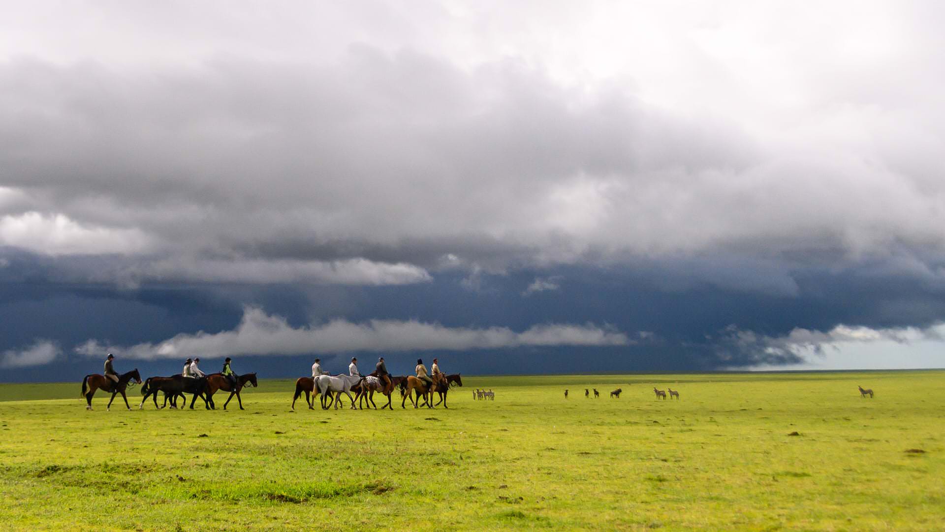 Rain Clouds with horse riders on the Serengeti